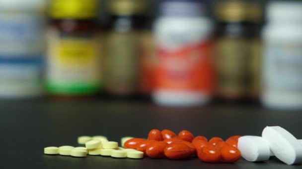 Médicaments ou compléments alimentaires sur fond noir et bocaux avec pilules - Séquence, vidéo