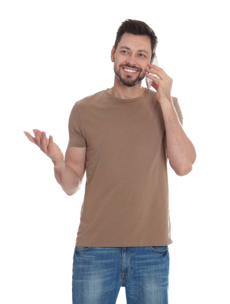 Man talking on phone against white background - Foto, afbeelding