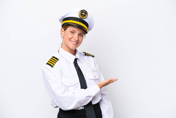 Aereo donna pilota caucasico isolato su sfondo bianco che presenta un'idea, mentre guardando sorridente verso - Foto, immagini