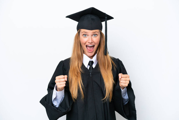 Young university graduate caucasian woman isolated on white background celebrating a victory in winner position - Foto, immagini