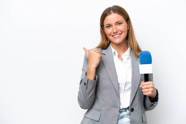 Jovem caucasiano apresentador de tv mulher isolada no fundo branco apontando para o lado para apresentar um produto - Foto, Imagem