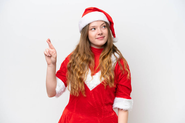 Young caucasian woman with Christmas dress isolated on white background with fingers crossing and wishing the best - Foto, Imagem