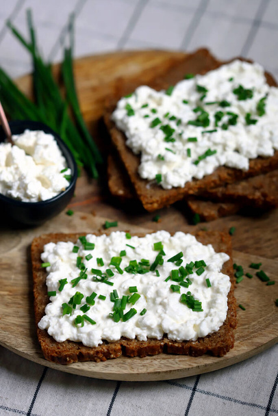 Ανοιχτά σάντουιτς με ψωμί σίκαλης και λευκό τυρί cottage με πράσινα κρεμμύδια. Υγιεινό πρωινό ή σνακ. - Φωτογραφία, εικόνα