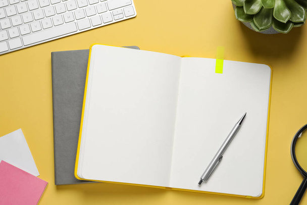 Flat lay composition with stylish notebooks on yellow background - 写真・画像