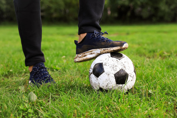 Man with dirty soccer ball on green grass outdoors, closeup - Fotoğraf, Görsel