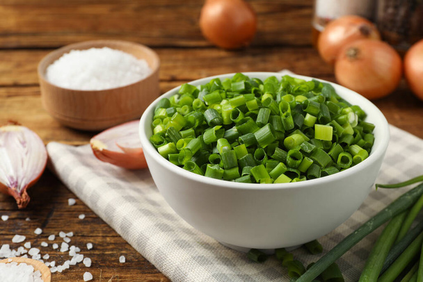 Chopped green onion in bowl on wooden table - Foto, Imagem