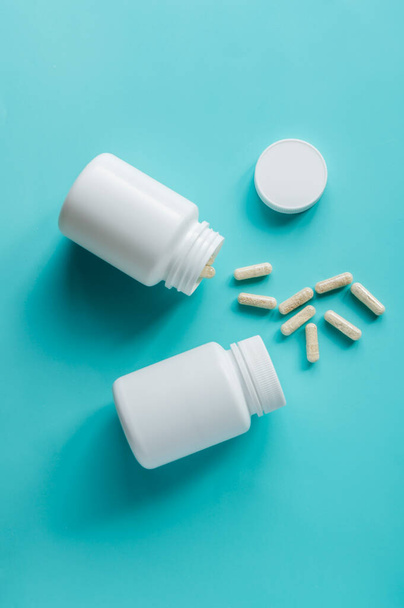 White pill bottles on blue background. Health care food supplements, vitamins and medicaments. - Foto, imagen