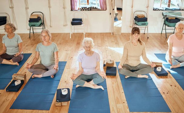 Starsza kobieta, joga i medytacja dla zdrowia duchowego, wellness lub spokojny zen ćwiczenia relaksacyjne w studio. Starsze kobiety relaksujące się na zajęciach jogi i medytujące dla zdrowej kondycji, umysłu i ciała. - Zdjęcie, obraz