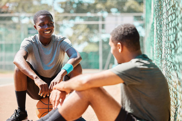 Basketball, sport and athlete friends talk after training, exercise and sports outdoor. Game conversation on the basketball court ground talking about team strategy on a relax break from fitness. - Φωτογραφία, εικόνα