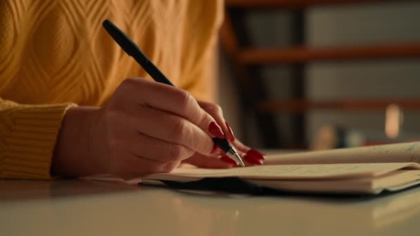 szczegóły nierozpoznawalne notatki do pisania kobiet lub notatnik z listą zakupów na palcach biurka z czerwonym lakierem do paznokci - Materiał filmowy, wideo