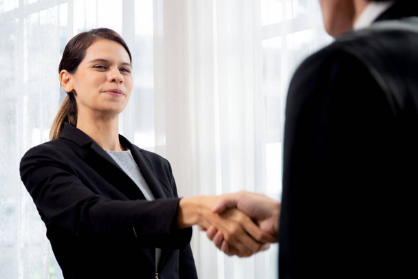 オフィスでの交渉の成功とお祝いの合意ながら幸せなビジネスの男性と女性立って握手一緒に挨拶しながら、ビジネスマンやパートナー握手、ビジネスコンセプト. - 写真・画像