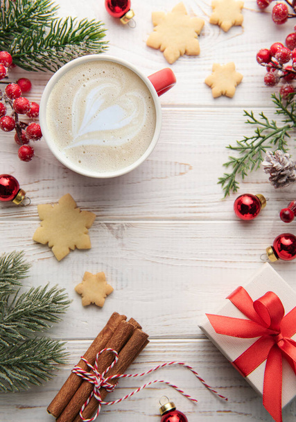 Tazza di caffè macchiato e decorazione natalizia su sfondo bianco in legno. Natale e Capodanno concetto di celebrazione. Vista dall'alto con spazio di copia, disposizione piatta. - Foto, immagini