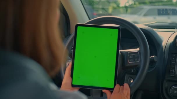 mujer vista trasera sosteniendo tableta digital con conductor de pantalla verde durante el viaje por carretera - Imágenes, Vídeo