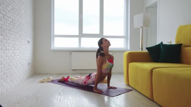 Femme mince et grande faisant des exercices sur tapis de yoga. À mi-coup - Séquence, vidéo