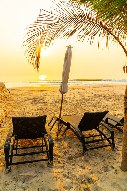 parasol stoel strand met palmbomen en zee strand bij zonsopgang - vakantie en vakantie concept - Foto, afbeelding