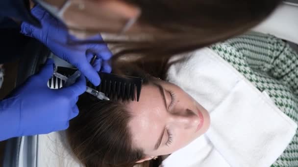 Close-up de uma mulher tricologista injetando uma seringa em uma cabeça de mulher. Tratamento de cabelo de cabeça em um salão de beleza. Conceito de dermatologia e tricologia. Vídeo 4k de alta qualidade - Filmagem, Vídeo