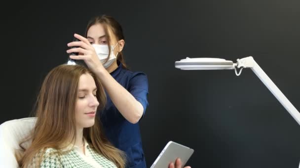 Szkennelés hajhullás esetére, egy trikológus műtétet végez egy fiatal nő fején. Vitamin injekciók, hogy javítsa a haj növekedését. 4k videó - Felvétel, videó
