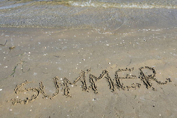 big capital letters text SUMMER on the sand of the beach - 写真・画像