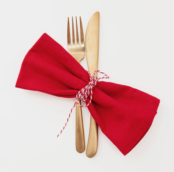 Een vakantietafel. Golden Cutlery en rode doek servet geïsoleerd op wit, bovenaanzicht. Kerst Nieuwjaar, feest diner - Foto, afbeelding