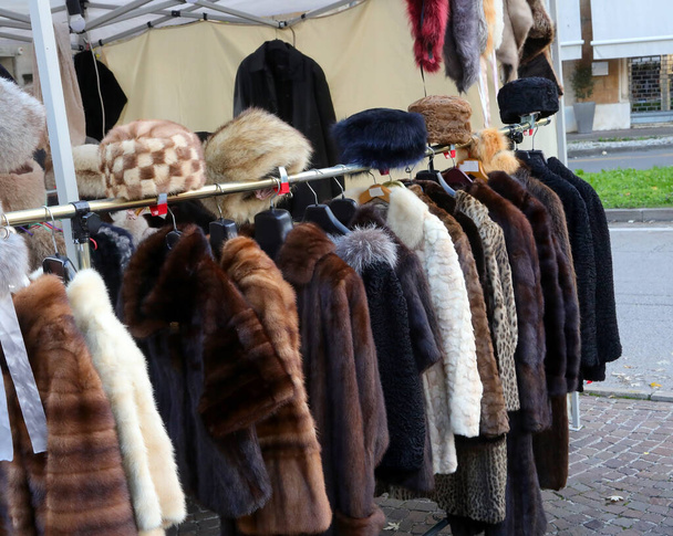 used fur and winter clothes for sale in the outdoor flea market stall - Foto, immagini