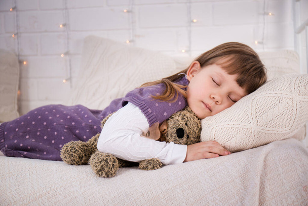 Tyttö makaa vintage sängyllä neulotut alusvaatteet. Joulun käsite - Valokuva, kuva
