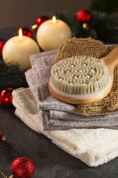 Asciugamani e spazzole per il corpo nell'arredamento di anno nuovo su uno sfondo scuro - Foto, immagini