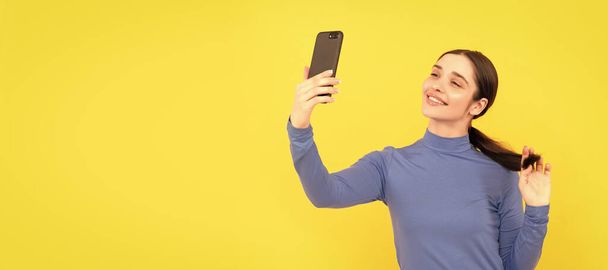 Vrouw geïsoleerd gezichtsportret, spandoek met kopieerruimte. glimlachende vrouw maken selfie foto op smartphone, selfie - Foto, afbeelding