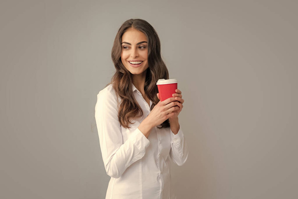 Beautiful young woman enjoying a cup of coffee while relaxing. People, drinks and leisure break, happy young woman with cup of tea or coffee - Photo, image