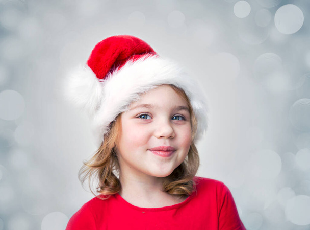 Happy child in Christmas hat portrait. New year concept. Little girl smiling. Toddler in red clothes. - 写真・画像