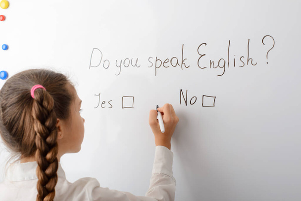Μιλάτε αγγλικά; επιγραφή στον πίνακα με πιθανές απαντήσεις Ναι ή Όχι. Μαθήτρια θα απαντήσει στην ερώτηση βάζοντας το σημάδι. - Φωτογραφία, εικόνα