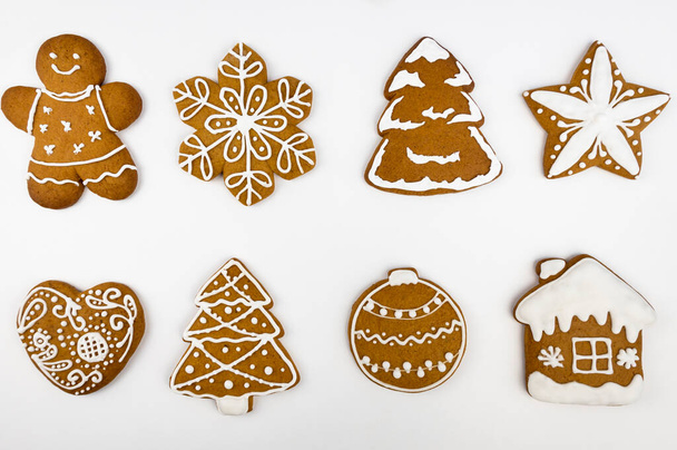 Christmas gingerbread in the form of a house, Christmas tree, heart, snowflake, star, Christmas ball and gingerbread man on a white background. View from above - Photo, Image
