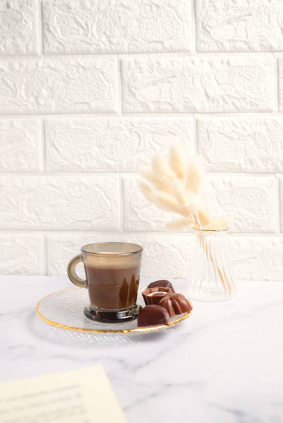 Chocolate candies and cup of coffee on kitchen - Φωτογραφία, εικόνα