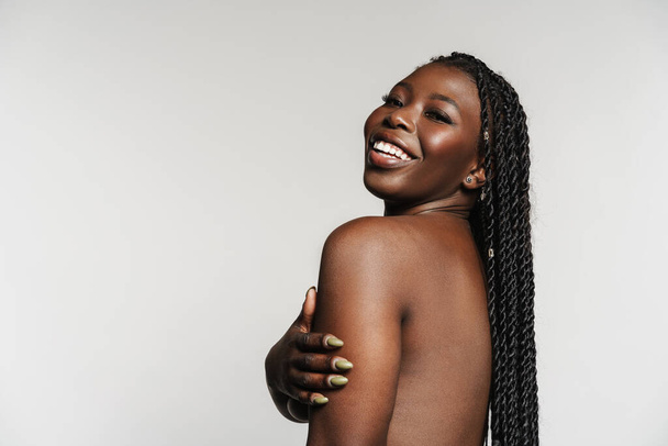 Shirtless black woman with afro pigtails smiling and looking at camera isolated over grey background - Fotoğraf, Görsel