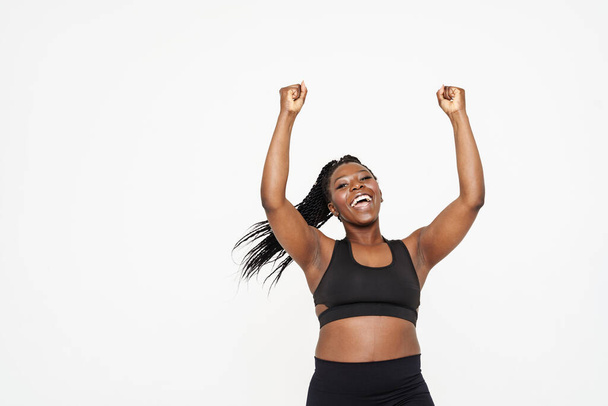 Black young woman screaming while making winner gesture isolated over white background - Foto, afbeelding