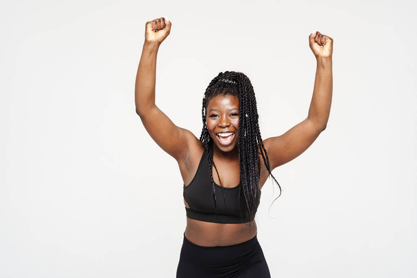 Black young woman screaming while making winner gesture isolated over white background - Foto, Imagen