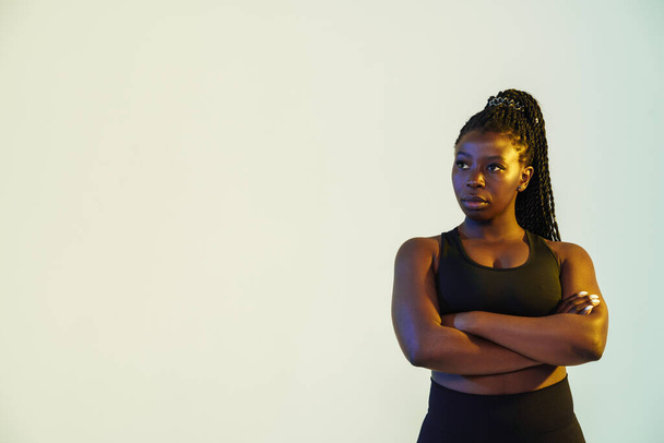Black young sportswoman posing with arms crossed isolated over white background - Fotó, kép