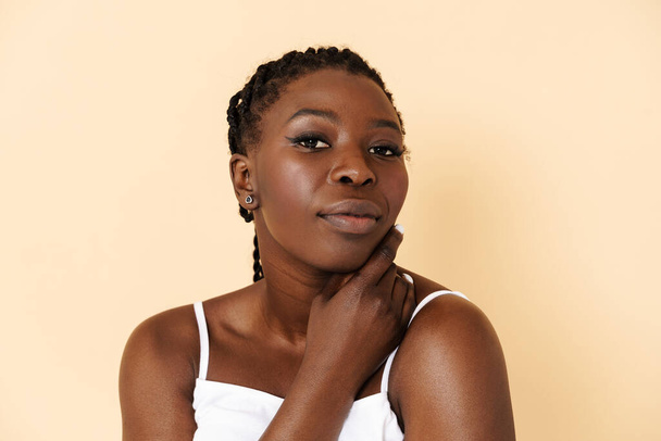 Black young woman with afro pigtails posing in underwear isolated over beige background - Foto, afbeelding