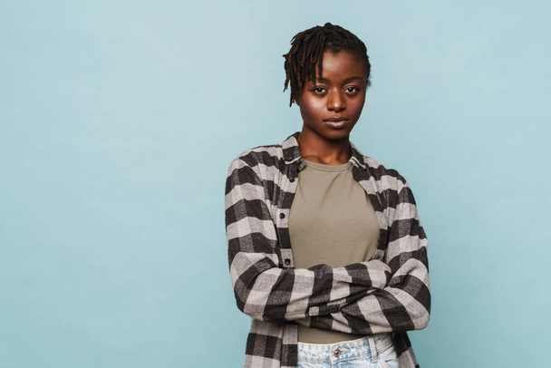 African american young woman wearing plaid shirt standing with arms folded isolated over blue background - Foto, immagini