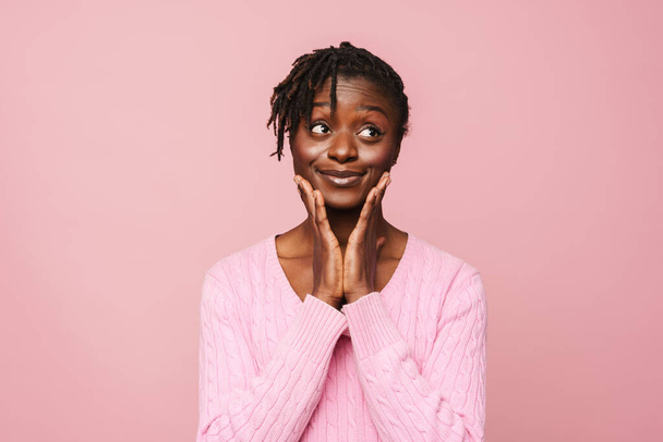 Black young woman with dreadlocks smiling and looking aside isolated over pink background - Photo, Image
