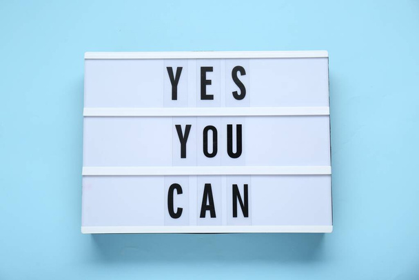 Lightbox with phrase Yes You Can on light blue background, top view. Motivational quote - Zdjęcie, obraz