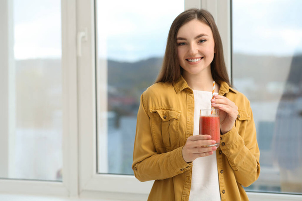Beautiful young woman with delicious smoothie near window. Space for text - Foto, Imagem