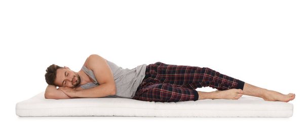 Man sleeping on soft mattress against white background - Foto, Imagem