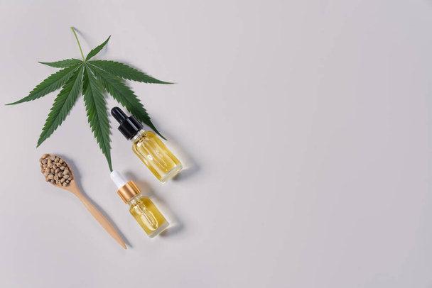 Legalisiertes Cannabis für medizinische Zwecke Konzept in flacher Lageansicht mit CBD-Ölextrakt aus Marihuana in Glasflasche mit Tropfdeckel und grünem Hanf auf leerem Hintergrund zum Kopieren. - Foto, Bild