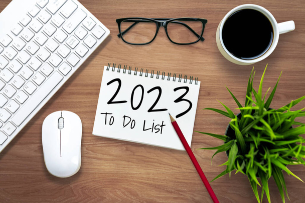 2023ハッピー新年決議目標リストと計画設定-新年の目標と決議設定の計画リストについて書かれたノートブック付きのビジネスオフィスデスク。変化と決意の概念. - 写真・画像
