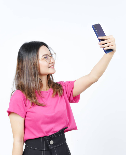 Tome un selfie usando Smartphone de hermosa mujer asiática aislado en fondo blanco - Foto, imagen