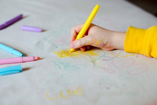 The child hand drawing with felt-tip pen on the upholstery of the couch. Furniture fabric. Cleaning concept. High quality photo - Photo, Image