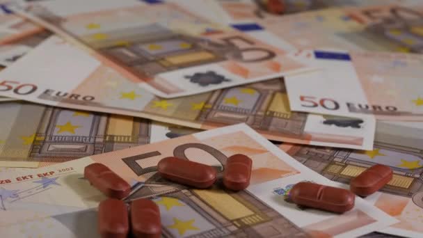 茶色の錠剤の閉鎖ショットは50ユーロ紙幣にドロップされます。スタジオで撃たれた。高価な医療や医療の概念に十分なお金を持っていない人々. - 映像、動画