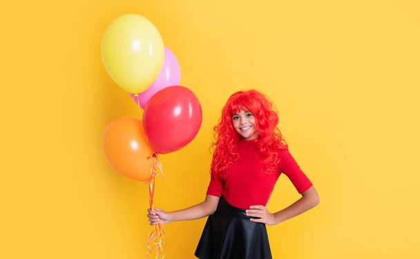 happy child with party balloon on yellow background. - Фото, изображение