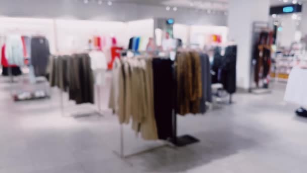 Mode, detailhandel en winkel, wazig interieur uitzicht van kleding kledingwinkel in luxe winkelcentrum als defocus achtergrond. Hoge kwaliteit 4k beeldmateriaal - Video