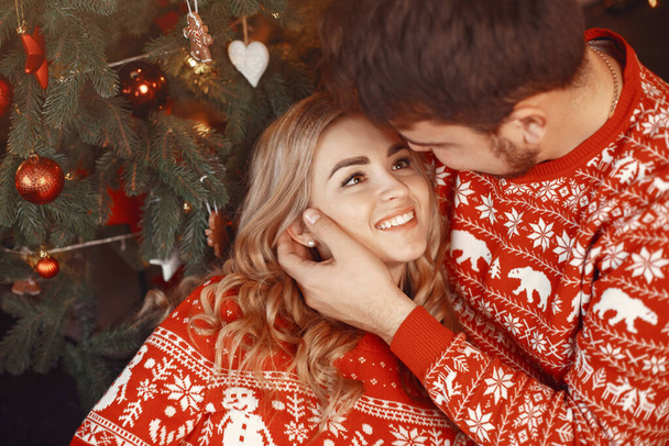 People in a Christman decorations. Man and woman in a red sweater. Family at home. - Foto, Imagen